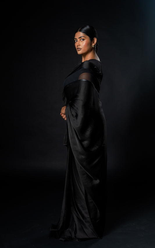 Woman wearing Ready to Wear Black Modern Saree from Rebel Roots, shining a dark background