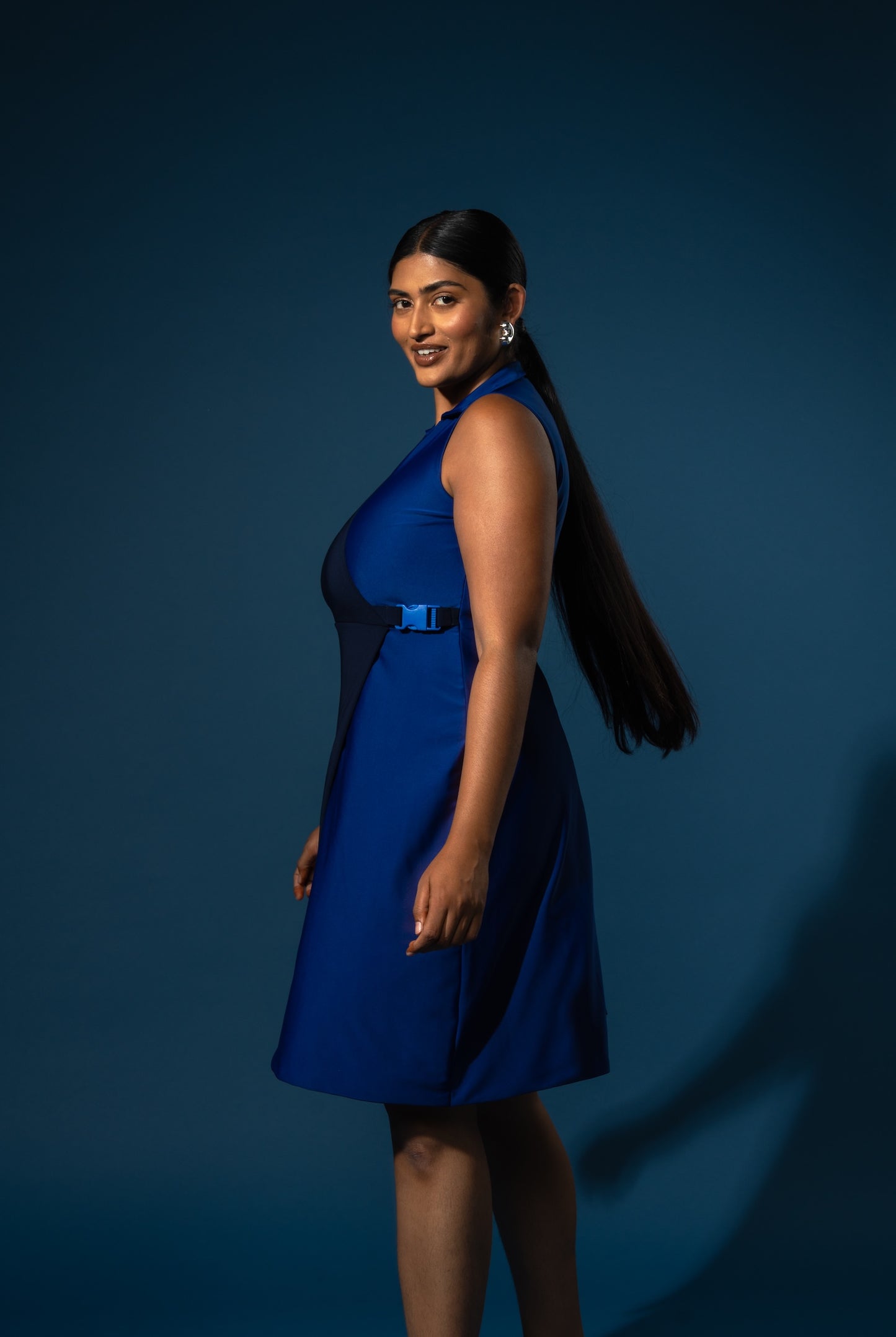 Woman wearing a blue dress against a dark blue background