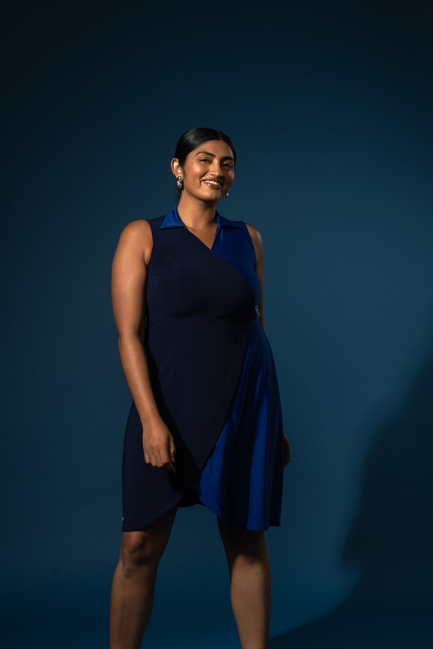 Woman wearing a blue dress against a dark blue background