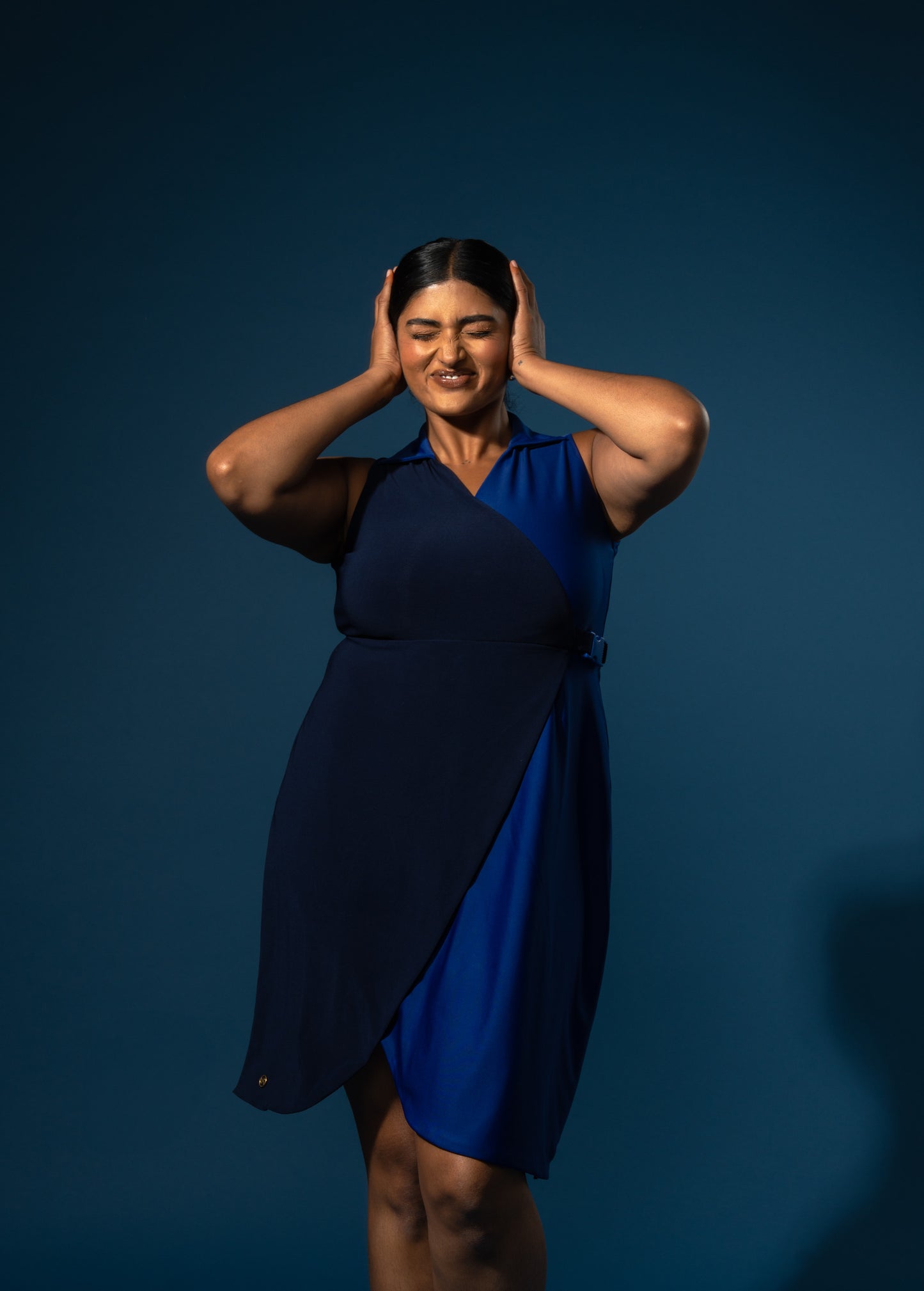 Woman wearing a blue dress against a dark blue background