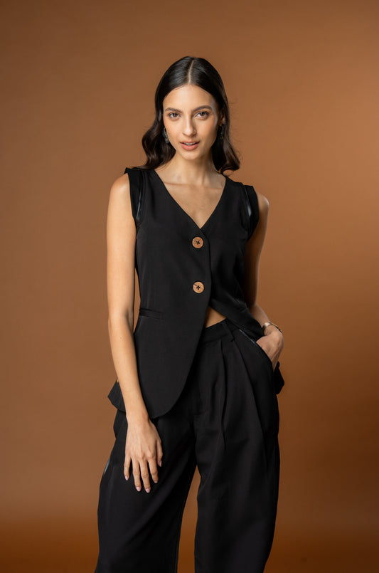 Woman wearing a black sleeveless top with buttons and wide-leg pants - Powerful coord set from Rebel Roots.