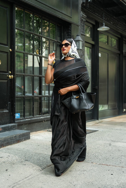 Woman in a black Label Rebel Roots Capsule Ready to Wear Saree standing on a city street.