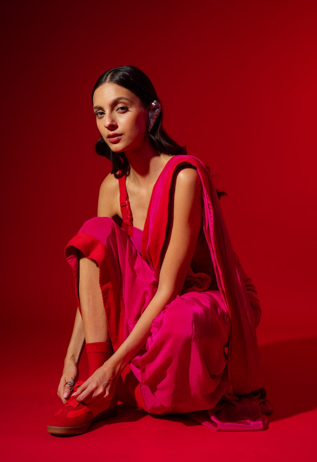 Woman in a bright pink Rebel Roots Buckle Saree. Ready to wear saree for the modern woman that pairs well even in the red shoes