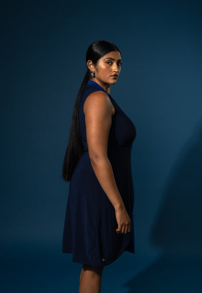 Woman wearing a navy blue dress against a dark blue background