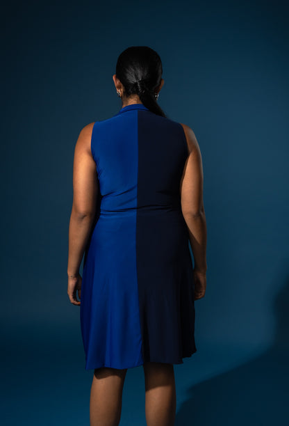 Person wearing a blue dress against a dark blue background