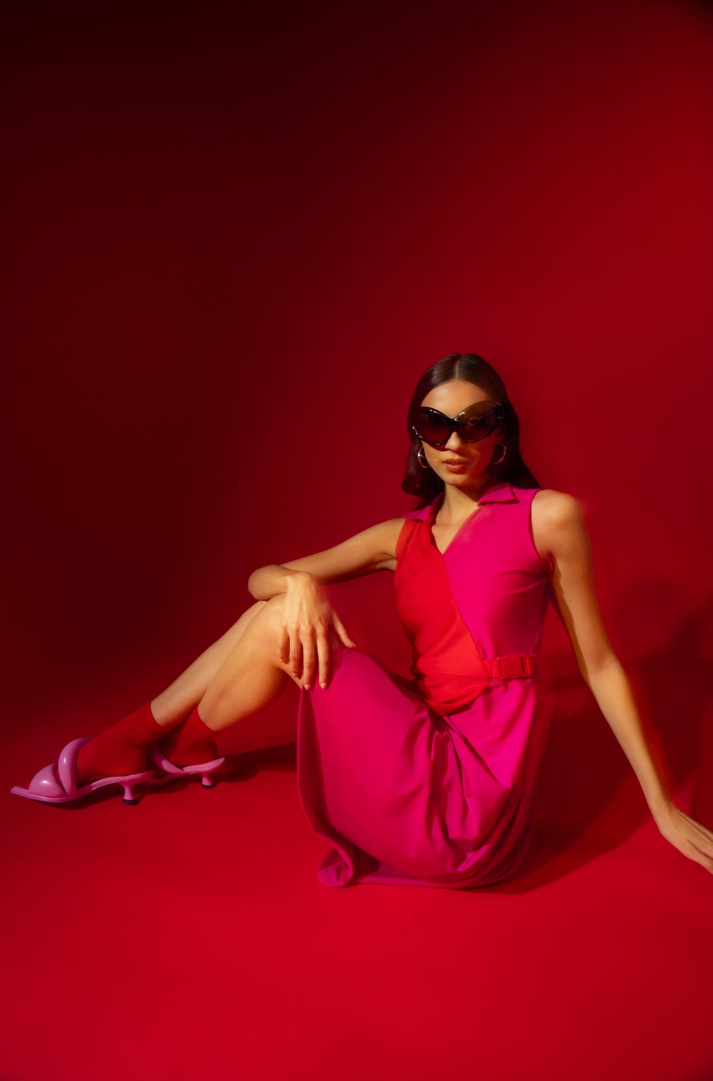 Woman in a red dress sitting on a red background