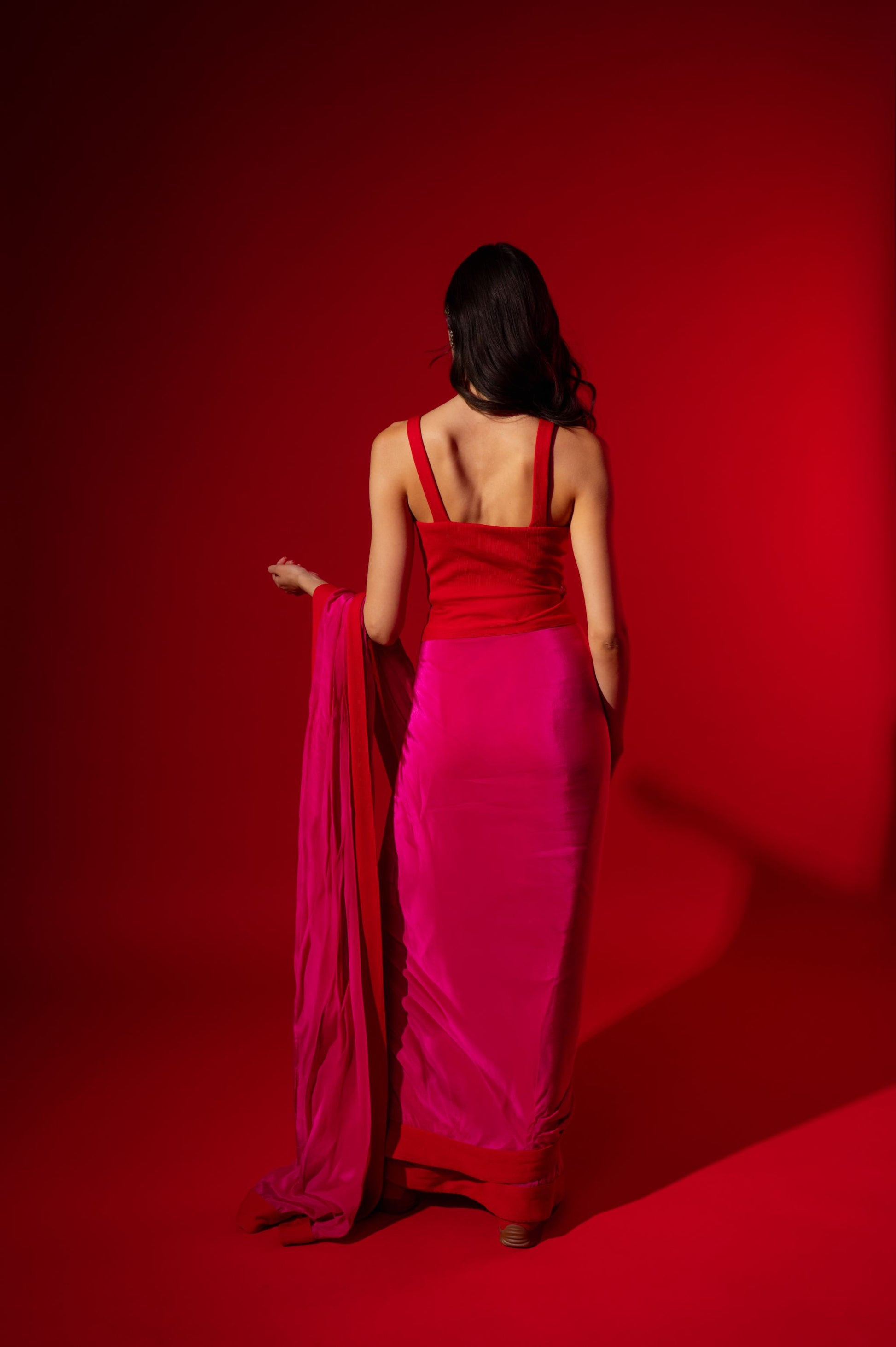 Woman in a red dress standing against a red background