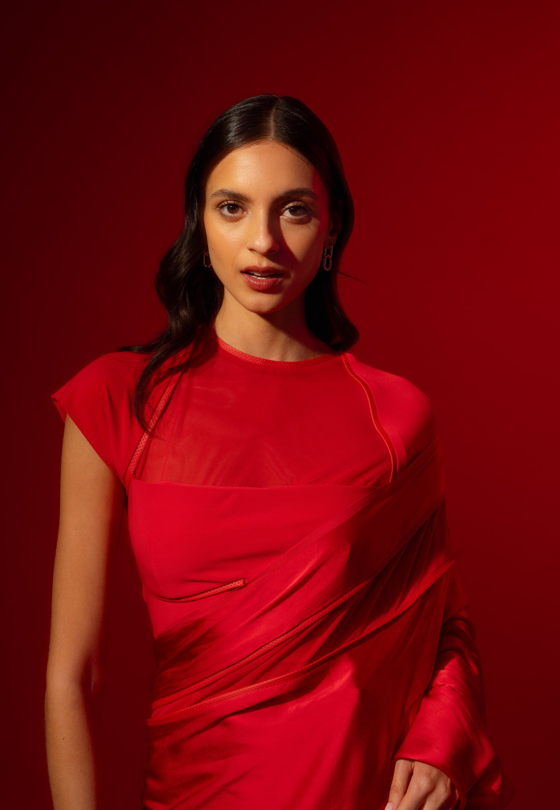 Woman wearing a pre-stitched Red Saree, & a modern red blouse. Rebel Roots Sarees are comfortable and Ready to wear. The blouse is modern and suitable for office and cocktail party.
