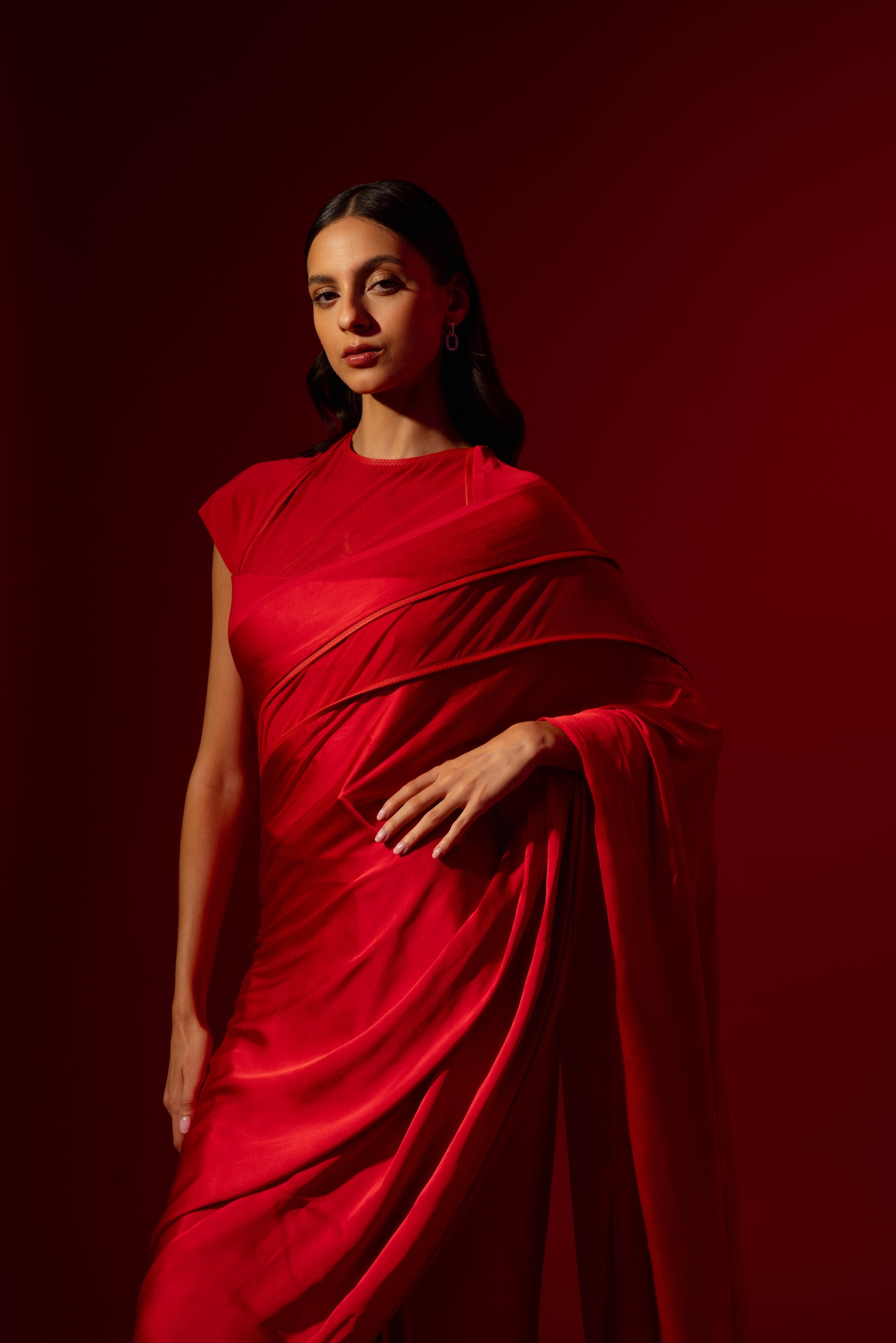 Woman wearing a perfect red cocktail saree. Saree is pre-stitched and with a modern blouse.