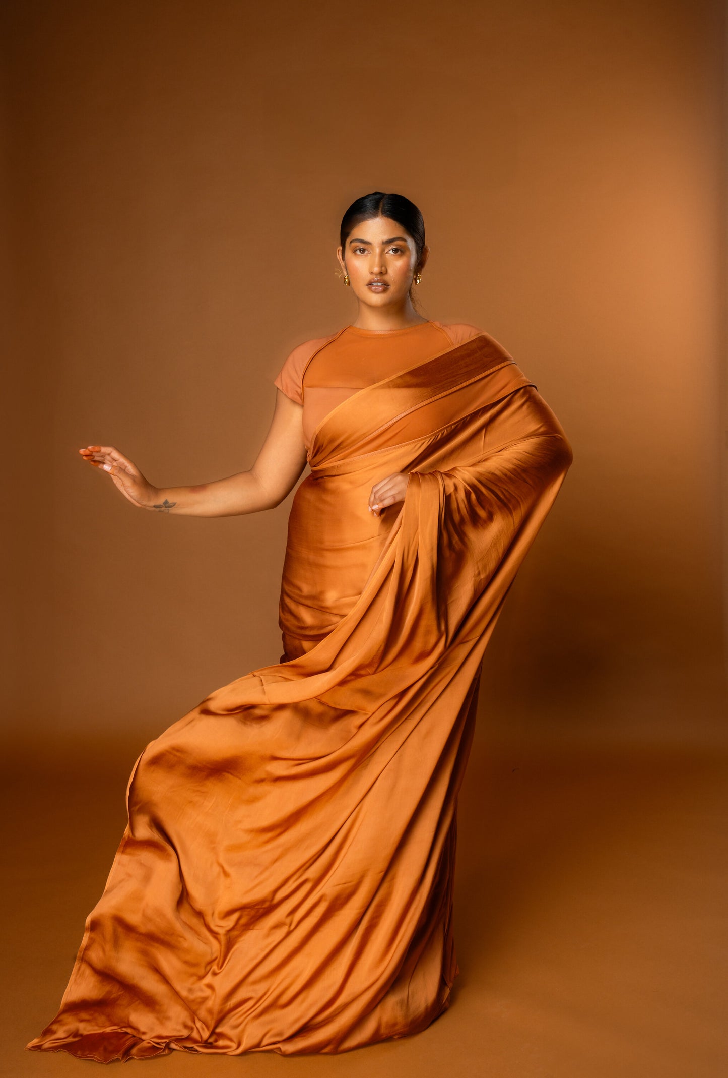 Woman wearing a modern Tan coloured saree - Label Roots Capsule Blouse and Saree - Pre-stitched and Ready to wear. 