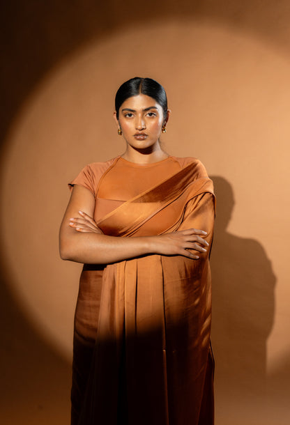 Modern Woman wearing a Tan saree. Saree has modern blouse with net stitching. The Rebel Roots saree is pre stitched